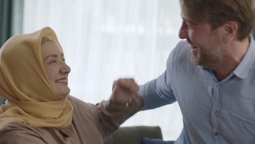 The man who comes to visit his old mother in a turban hugs his mother. Elderly woman and her son smiling happily at camera. Portrait of happy mother and son. | Shutterstock HD Video #1089714615