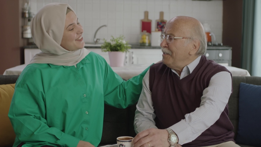 Happy loving old man drinking Turkish coffee in traditional cup. Old man having a good time chatting with his visiting daughter while drinking Turkish coffee.Happy father and daughter portrait. | Shutterstock HD Video #1089714689