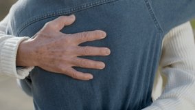 Unrecognizable senior man in white sweater hugging his dear wife. Closeup shot of male hands rubbing and stroking female back while embracing. Romance, relationship concept - Powered by Shutterstock - Get 15% off with code: PIKWIZARD15