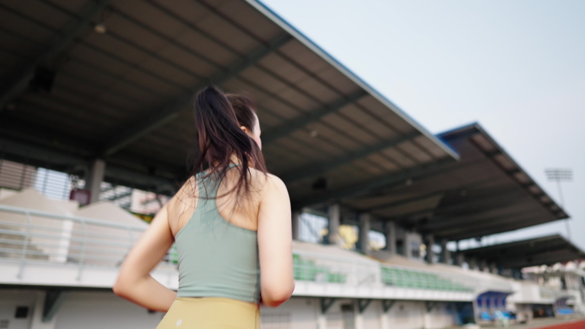 asian women middle aged running during sunny morning on stadium track
