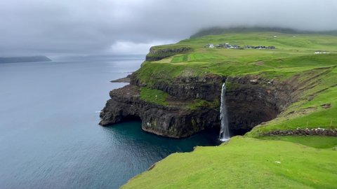 Beautiful cinematic aerial footage of Gasadalur waterfall and village and landscapes in the Faroe Islands