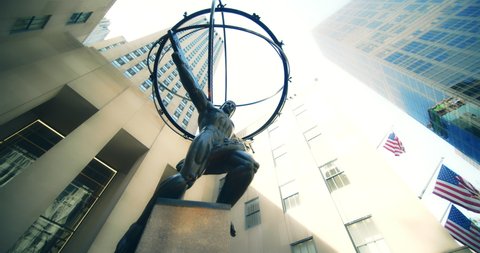 New York, New York United States - April 23,  2022: Low, wide angle rotation of Atlas Statue in front of Rockefeller Center in NYC