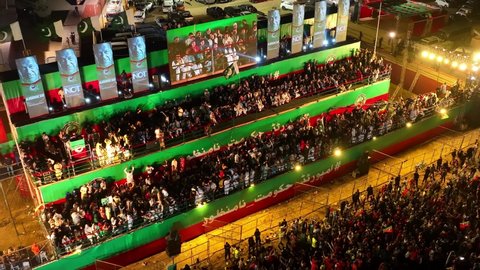 Karachi , Pakistan - 04 16 2022: Aerial View Of Stage With Speaker On Large Screen Viewed By Supporters At PTI Party Rally In Karachi At Night. Circle Dolly