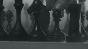 Chess pieces placed on the chessboard. Black and white video of chess game