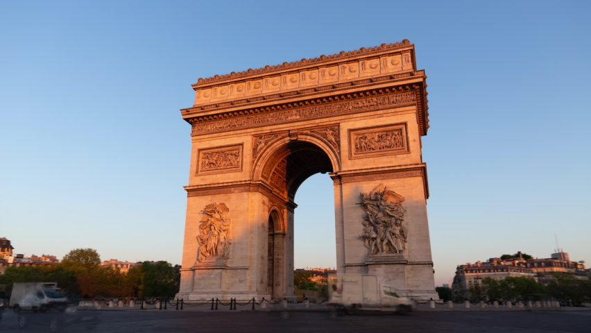 Paris France: Triumphal Arch of the Star (Arc de Triomphe de l'Étoile) - a famous landmark and tourist attraction at sunrise. Traffic on the street on a sunny morning under clear blue sky - hyper-lapse. | Shutterstock HD Video #1089722549