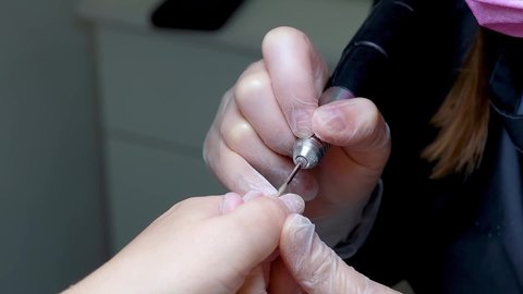 Manicurist's hands do the work of grinding nails