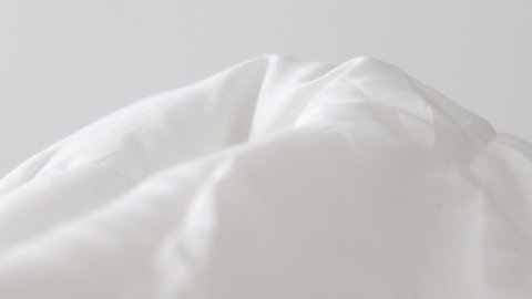 defocused close up 4k video of white blanket and some gentle moves under. morning wake up, bedroom. good morning concept, sunny day, light