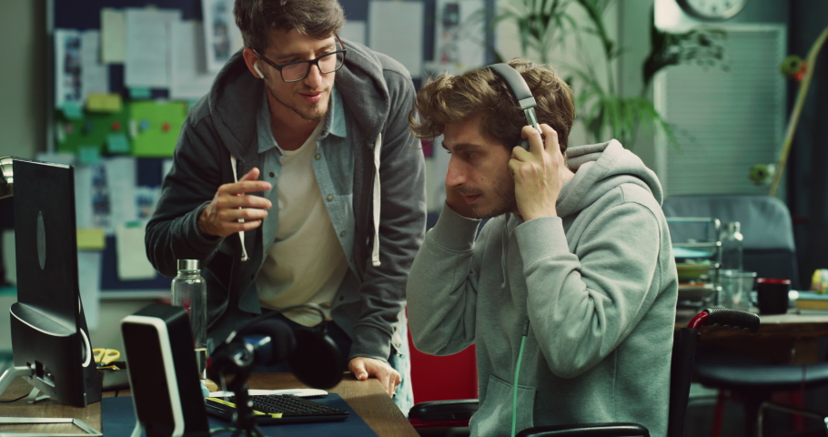 Cinematic shot of young male graphic designer with disabilities use wheelchair and his colleague are discussing about new strategy while working together on project in modern creative studio. Royalty-Free Stock Footage #1089726717