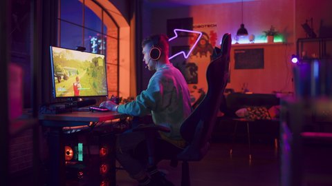 Professional eSports Gamer Winning Online Tournament. 3D Shooter Video Game with Lots of Action and Fun on His Powerful Personal Computer at Home. Cyber Gaming Stylish Retro Neon Room. Real Gameplay.