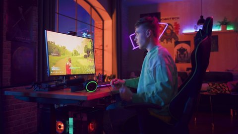 Gaming at Home: Gamer Putting on Headphones and Playing Online Video Game on Computer. Stylish Male Player Enjoying 3D Shooter with Showing Arcade Online Multiplayer PvP Battle. Real Gameplay.