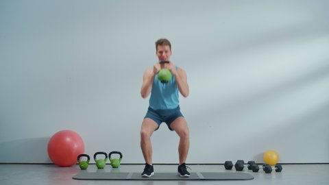 Fitness Course Internet Video with Young Athletic Personal Trainer Explaining Core Strengthening Workout Routine with Kettlebell. Fit Online Coach Showing How to Burn Fat for Beginners.