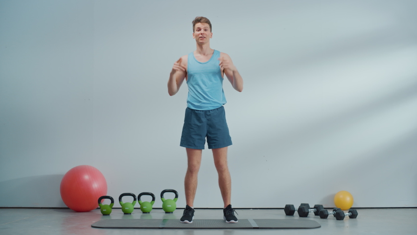 Fitness Course Internet Video with Young Athletic Personal Trainer Explaining Cardio Workout Routine Starting with High Knees Exercise. Fit Online Coach Showing How to Lose Body Weight. Royalty-Free Stock Footage #1089729285