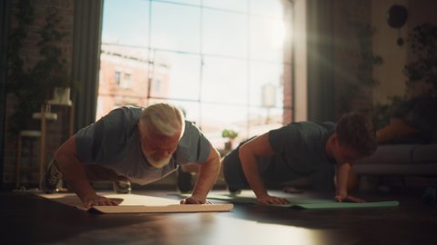 Middle Aged Man Exercising at Home with Personal Trainer. Senior Male Strengthening Body Muscles with Push-Ups Workout. Son Training with Sporty Father, Motivating Each Other by Giving a High Five.