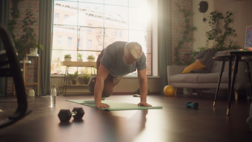 Strong Athletic Fit Middle Aged Man Doing Mountain Climber Exercises During Morning Workout at Home in Sunny Apartment. Concept of Healthy Lifestyle, Fitness, Recreation, Wellbeing and Retirement. Royalty-Free Stock Footage #1089729457