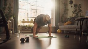 Strong Athletic Fit Middle Aged Man Doing Mountain Climber Exercises During Morning Workout at Home in Sunny Apartment. Concept of Healthy Lifestyle, Fitness, Recreation, Wellbeing and Retirement. - Powered by Shutterstock - Get 15% off with code: PIKWIZARD15