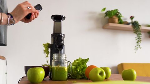 A woman's hands prepare celery juice with a juicer