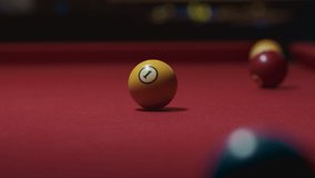 Random hitting of colorful number one ball on retro red felt pool table in club, pub, bar. White ball strikes yellow ball. No people in high quality 4k footage video. Cinematic view of pool playing.