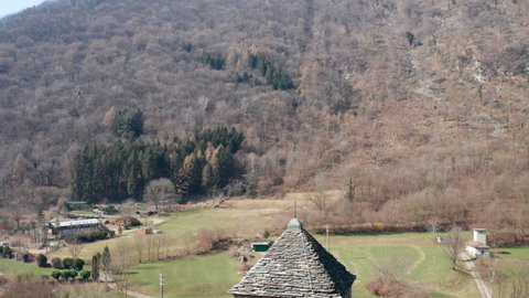 Aerial view of the bell tower of the small ancient church of St. Alexander, an example of the widespread Romanesque rural architecture of XII century in the Como area (Italy).