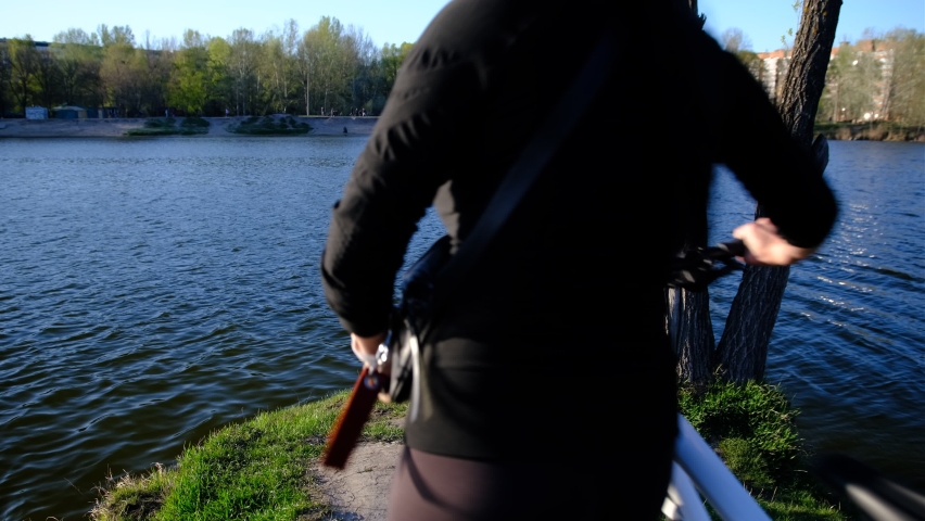 a bicycle with a woman in the sunset overlooking the lake, river