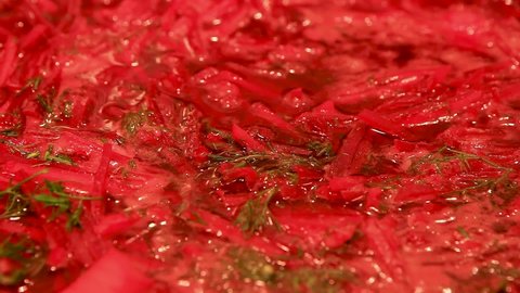 Cooking at home. Macro surface of borscht in a saucepan. The red beetroot soup begins to boil slowly in the pot. Steaming
