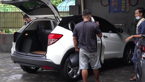 Tangerang, Indonesia – April 29, 2022, car wash, some people who work cleaning cars. clean wash. Dry clean and car exterior details. Car body cleaning. Clean the car panel from dust.