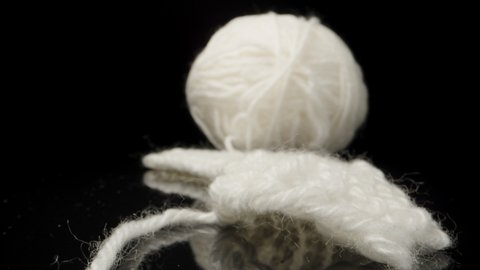 A ball of white woolen threads on black glass... Dolly slider extreme close-up. Laowa Probe