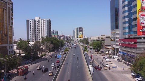 Beautiful city shot of Karachi showing traffic going by road surrounded by commercial buildings and offices with commercial colorful billboards. Karachi, Pakistan. 25th March 2021 