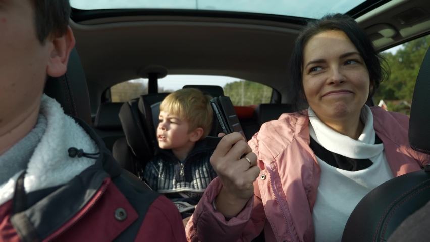 Happy Friends Travel Together by Car. Group of Tourists Journey Family Trip. SUV Panoramic Glass Roof. Male Female Winter Attire Autumn Season. 2x Slow motion 60fps 4K