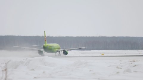 NOVOSIBIRSK, RUSSIA - JANUARY 22, 2017: Jet airplane of S7 Airlines picking up speed before departure at Tolmachevo Airport on a winter. Airplane speeding up before takeoff on a snowy airfield