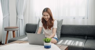 Smiling young businesswoman using laptop sitting at home office desk, happy female customer make distant online work