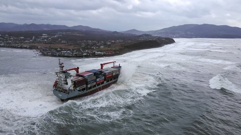 A drone view of the container ship RISE SHINE, which ran aground during a storm. Shipwreck. Giant waves crash against the side of the ship, covering the ship - NOV 09, 2021 Nakhodka, Russia