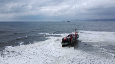 A drone view of the container ship RISE SHINE, which ran aground during a storm. Shipwreck. Giant waves crash against the side of the ship, covering the ship - NOV 09, 2021 Nakhodka, Russia