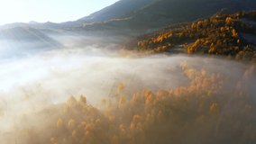 Sunrise etting light shining brightly on pink and purple sky above thick layer of white fog covering mountainous canyon panorama view, fly realtime 4K drone video