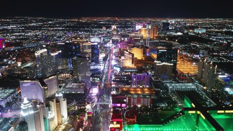 Las Vegas Strip Nevada, Apr. 2022. Entertainment gambling capital, holiday concept 4K. Cinematic aerial of scenic New York hotel, modern Cosmopolitan resort and green MGM grand at night illumination