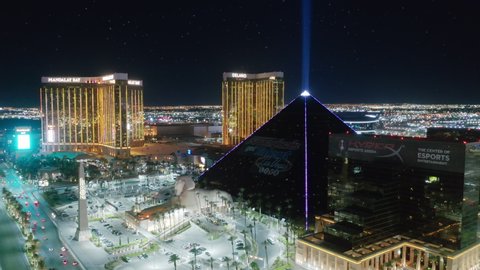 Las Vegas at night, Nevada, Apr. 2022. Scenic Luxor Pyramid hotel with ray of light shining brightly at night. USA tourism concept, entreatment capital for adults, best weekend vacation idea to relax