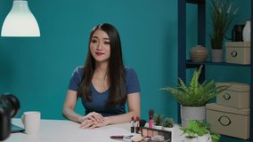 Content creator recording beauty videoblog with phone camera, doing makeup tutorial to give tips. Lifestyle blogger filming video on camera with streaming equipment and cosmetics.