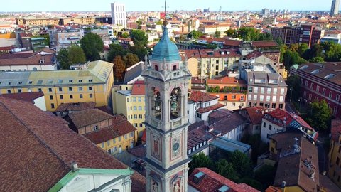 Aerial view of the Basilica of Santo Stefano Maggiore in the center. Drone view of the rooftops during the day. church. Stone building. Bell tower. People in the city. Milan. Italy April 2022