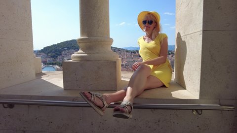 Woman with hat on top view of Split city of Croatia on Adriatic Sea and Dalmatia. Panoramic bell tower of Saint Domnius Cathedral. Aerial view of the cityscape in summer. Ancient Roman Empire town.