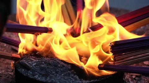 close up putting joss sticks on fire. Burn incense. Asian religious concept. Super slow motion