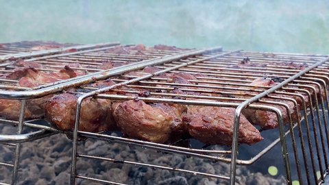 Close-up of grilling dish on barbecue. Barbecue grilling shish. Charcoal cooked meat. Delicious food on metal skewer in bbq. Time to picnic concept. Food festival. Pork at the stake. Fried pork