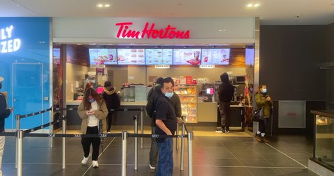 Toronto, Canada - April 29, 2022: Line up of people in a Tim Horton's cafeteria inside of the Scarborough Town Center, a famous shopping mall in the city