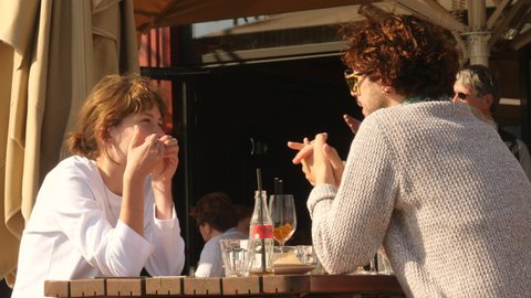 Amsterdam, Netherlands, April 25, 2022. Hip young people having a drink and talking at outdoor Lounge Bar.