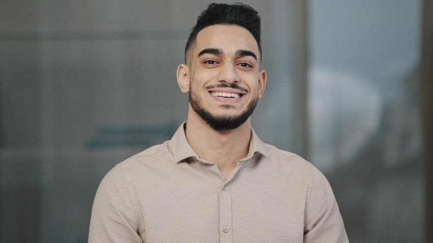 Happy young guy hispanic handsome man with toothy smile looking at camera male face portrait businessman smiling arab professional manager entrepreneur posing positive in modern office close up view Royalty-Free Stock Footage #1089760323