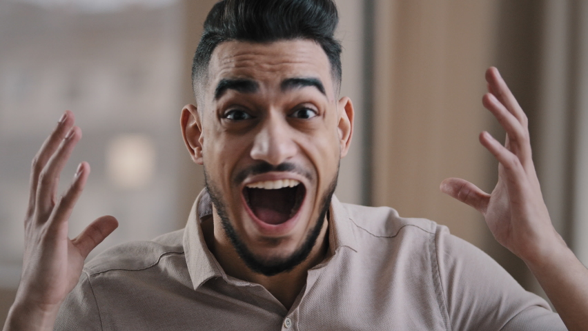 Close up shocked happy young hispanic male business man professional worker surprised looking at camera make big eyes rejoice victory amazed guy winner demonstrate wow reaction joyful face expression | Shutterstock HD Video #1089760337