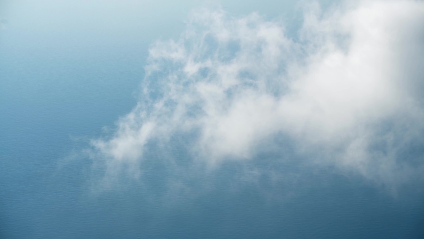 White clouds over the blue sea. Clouds forms and slowly moving in the sky. Summer weather at sunny day. Abstract sky nature background. 

