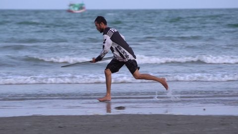 Hua Hin, Thailand – April 21, 2022: View of man playing skimboard at the hua hin beach. Skimboarder in slow motion at the beach