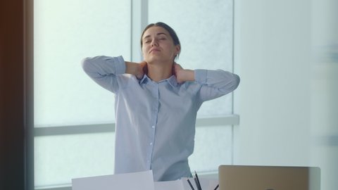 Woman Standing By the Table Massaging Back Suffering From Pain or Inflammation Processes Due to Long Sedentary Work at Office. Suffering Office worker Feeling Sick Because of all Work, Stress Backache