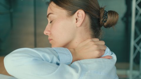 Close-Up of Woman Tired of Long Sedentary Lifestyle,Rubbing Massaging Neck.Female Experiencing Discomfort in a Result of Spine Trauma or Arthritis. Massaging and Stretching the Neck to Ease the Injury