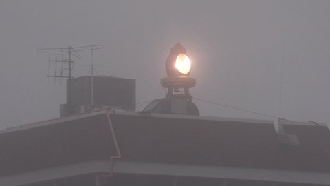 Toronto, Ontario, Canada April 2022 Airport control tower emergency beacon light flashing at night in the fog