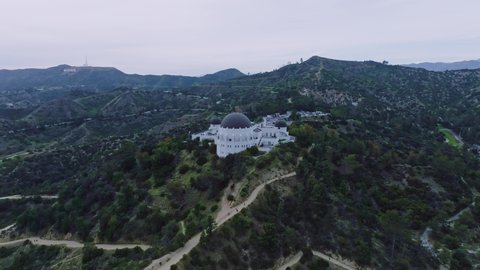 Los Angeles , California , United States - 04 28 2022: Griffith Observatory from Up Above, Aerial Drone Shot Approaching Iconic Observatory Nestled in Hollywood Hills